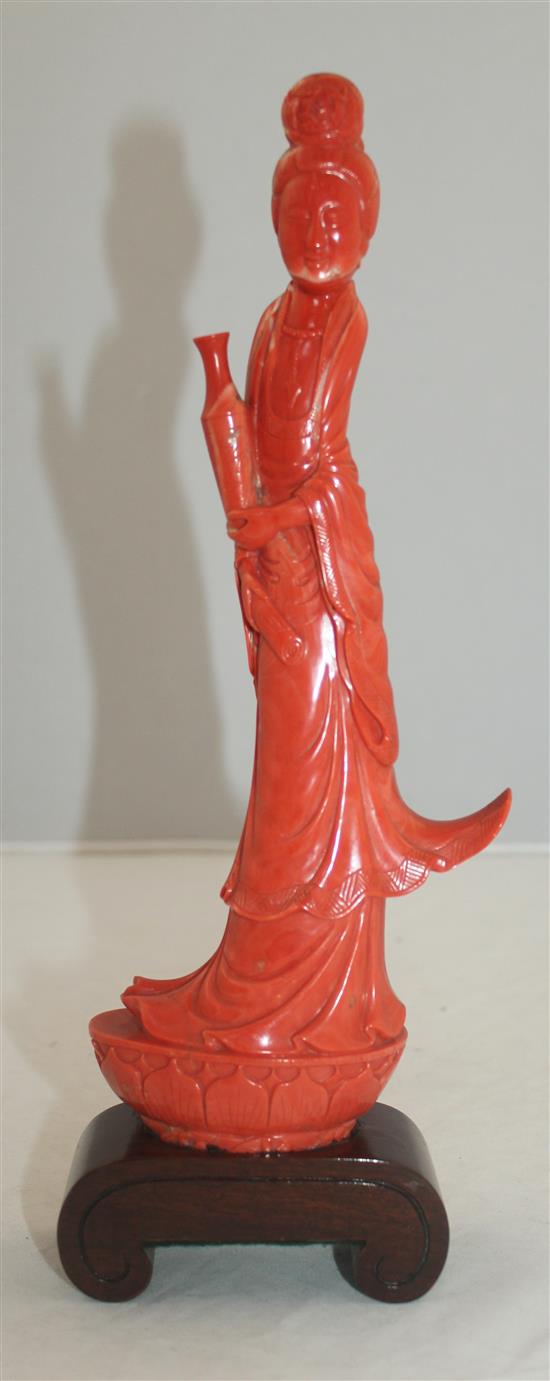 A large Chinese coral figure of Guanyin, 27.7cm incl. wood stand